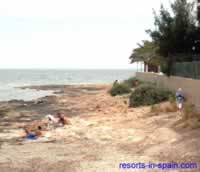 Rocky beach near Es Viver and no promenade