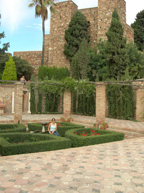 Young tourist sat in the gardens of the La Alcazaba fortress Malaga